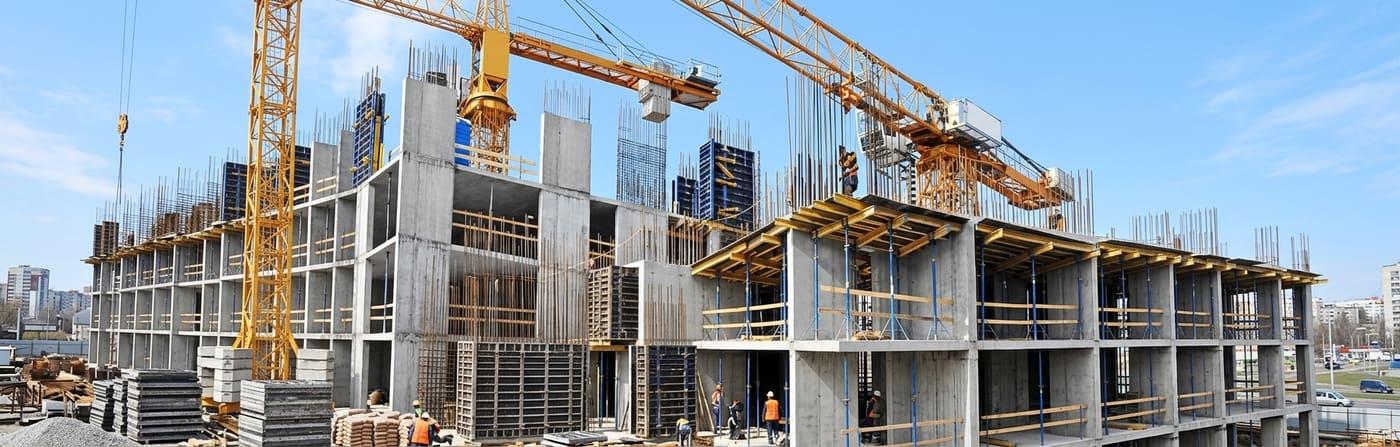 Chantier de construction avec grues, illustrant les travaux couverts par la garantie Dommages Ouvrage